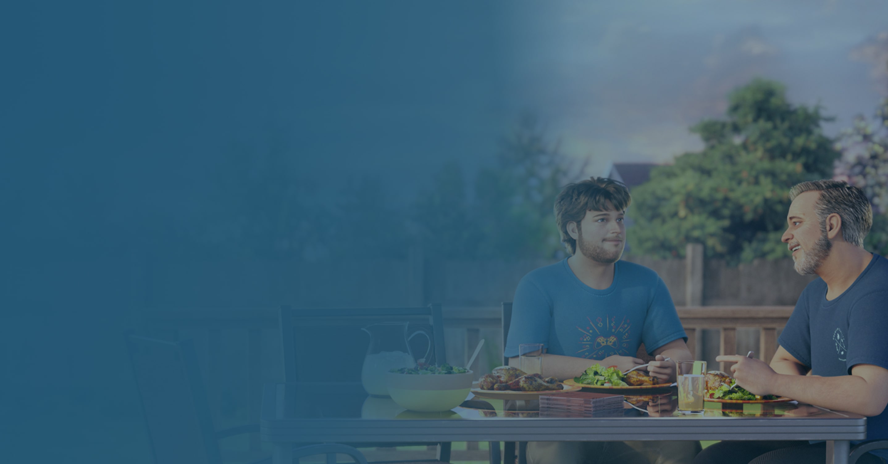 Father and teenage son eating dinner outside on patio
