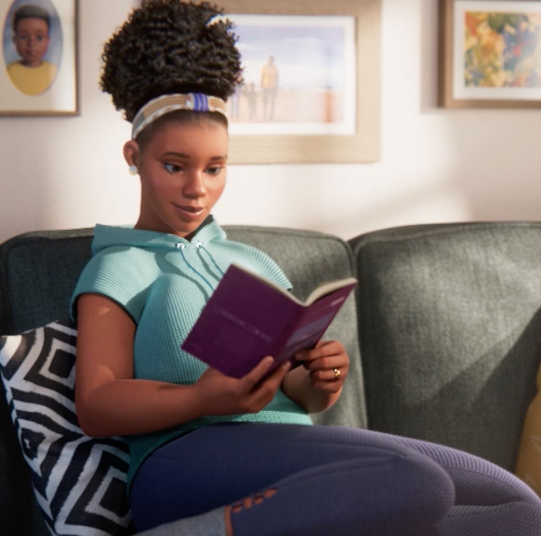 A female ABILIFY ASIMTUFII patient reading a book while sitting on a couch.